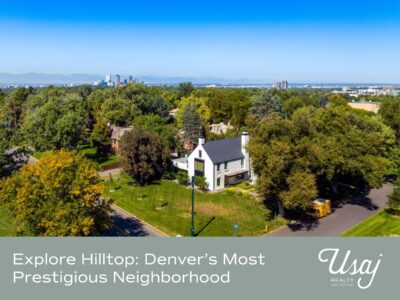 An aerial photo of the Denver Hilltop Neighborhood rests above white text on a gray background that reads, "Explore Hilltop: Denver’s Most Prestigious Neighborhood" next to the Usaj Realty logo in white.