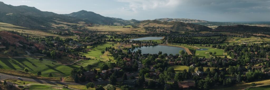An aerial photo of the Red Rocks Country Club and surrounding forest with small lakes and a golf course.