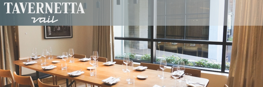 The Tavernetta logo in the upper left-hand corner sits over an image of the restaurant's table with place settings and a window.