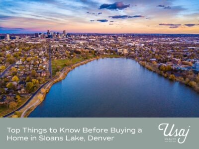 An aerial view of the Sloans Lake Denver neighborhood with a sunset behind it. Below, white text reads, "Top Things to Know Before Buying a Home in Sloans Lake, Denver" next to the Usaj Realty logo also in white. Behind the text the background is a soft sage color.