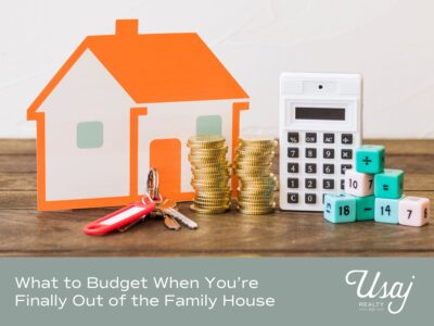 A photo of an paper orange house, keys, coins stacked, a calculator, and dice stacked sits above white text on a gray background that reads, "What to Budget When You’re Finally Out of the Family House" next to the Usaj Realty logo in white.