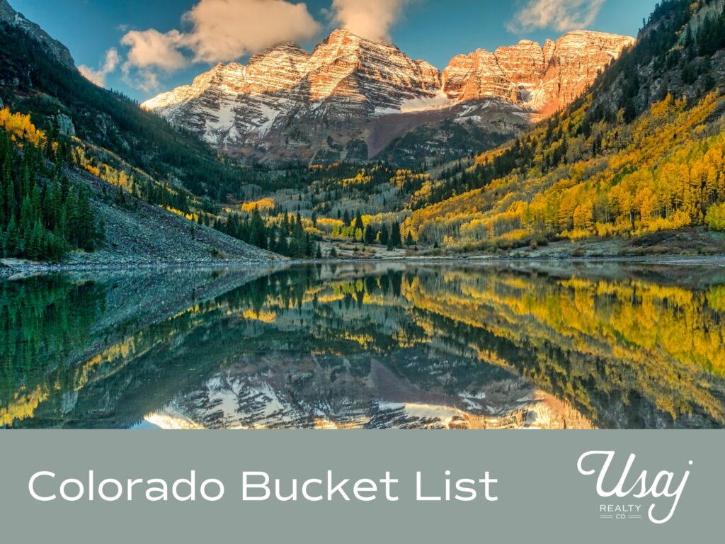 A photo of a mountain range called Maroon Bells in Aspen, Colorado sits above white text on a gray background that reads, "Colorado Bucket List" next to the Usaj Realty logo in white.