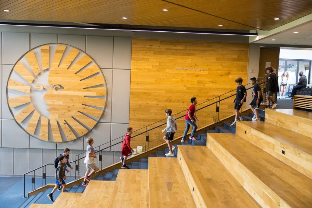 A Photo of inside the Denver school Kent Private School, with children walking up and down the stairs.