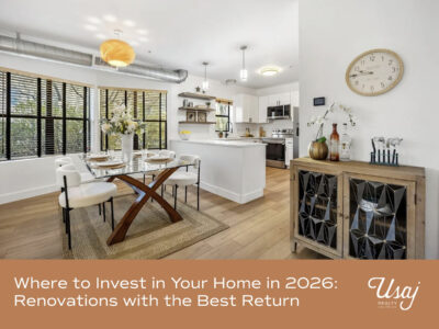 A photo of the interior of a home highlighting the kitchen and dining area rests above white text on an orange background that reads, "Where to Invest in Your Home in 2026: Renovations with the Best Return" next to the white Usaj Realty logo.