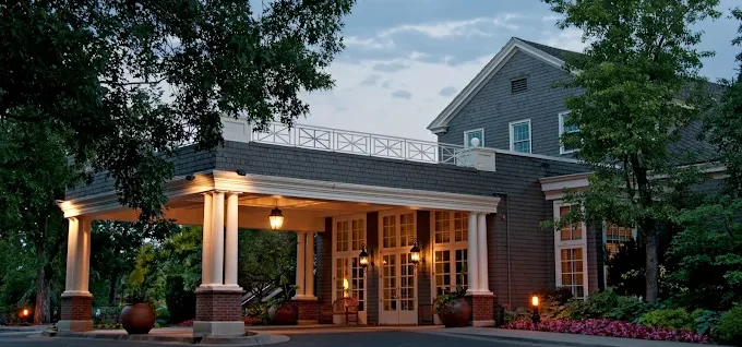 A photo of the entrance of the Denver Country Club and dusk.