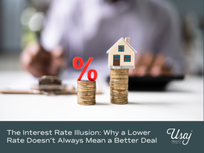A photo of coins stacked with a percentage symbol (%) and a small home sits above text that reads, "The Interest Rate Illusion Why a Lower Rate Doesn’t Always Mean a Better Deal" for a blog discussing the cost of waiting to buy a home.